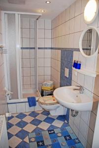 a bathroom with a sink and a toilet at Appartementhaus zur Brücke direkt am See in Sandort +64 photos