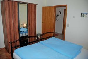 オストゼーバート・ゼリンにあるFerienappartement Lisaのベッドルーム1室(青い毛布付きのベッド1台付)