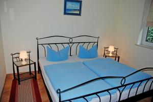 a bedroom with a bed with blue sheets and blue pillows at Ferienappartement Lisa in Ostseebad Sellin