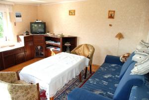 a living room with a table and a couch and a tv at Ferienhaus Sehlen auf Ruegen in Sehlen