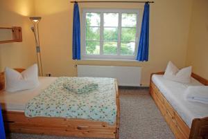 Puddeminにあるgro_zuegige Ferienwohnung mit Kaminのベッドルーム1室(ベッド2台、窓付)