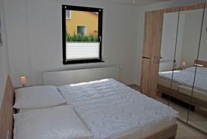 1 Schlafzimmer mit 2 Betten und einem Wandspiegel in der Unterkunft NEU - Ferienhaus mit Sonnenterrasse in Ostseebad Sellin
