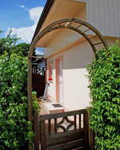 um portão de madeira com um arco em frente a uma casa em Villa Vitalis Ferienhaus Vitale em Ostseebad Sellin