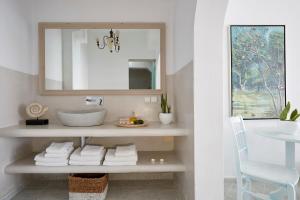 a bathroom with a sink and a mirror at Andromeda Villas & Spa Resort in Imerovigli