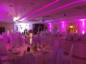 a room with white tables and chairs and purple lights at Gościniec Sikorka in Rypin
