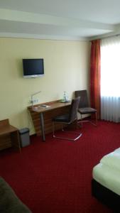 a hotel room with a desk and two chairs at Pension "Zum Raubritter" in Langquaid
