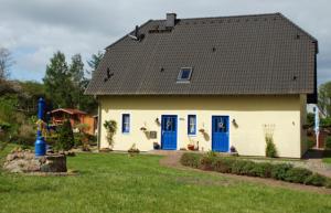 a house with a black roof and blue doors at Ferienappartements in Gager auf Ru in Gager