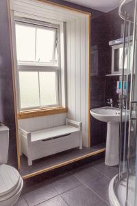 a bathroom with a toilet and a sink and a window at Bannockburn Inn in Helmsdale