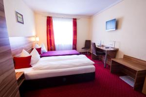 a hotel room with a bed and a desk at Pension "Zum Raubritter" in Langquaid