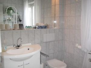 a bathroom with a sink and a toilet at Ferienhaus AS TO HUS in Büsum