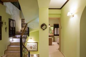 um corredor com uma escada com paredes verdes e uma escada em Elaion Terra Boutique Guesthouse em Theológos