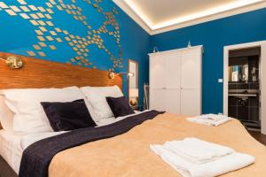 een slaapkamer met een groot bed met een blauwe muur bij Residence Vaclavska in Praag