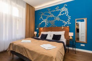 プラハにあるResidence Vaclavskaの青い壁のベッドルーム1室(大型ベッド1台付)
