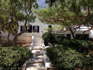 a walkway leading to a white house with trees at House in Kamares - Sifnos in Kamares