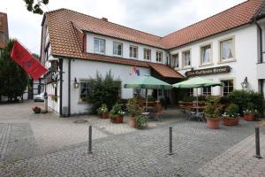 a building with a courtyard with tables and chairs at Hotel Altes Gasthaus Greve in Recke