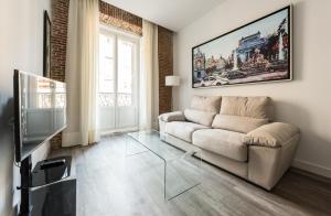 salon z kanapą i szklanym stołem w obiekcie Puerta Del Sol City Center w Madrycie