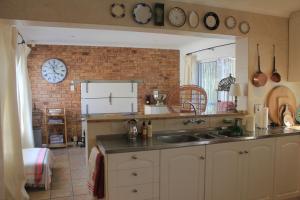 a kitchen with a sink and a brick wall at Fairhaven Beachhouse & Pool Blouberg seaside in Bloubergstrand