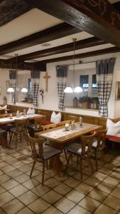 a restaurant with wooden tables and chairs in a room at Pension "Zum Raubritter" in Langquaid