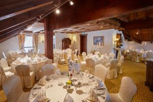 Gästezimmer Kamino في هوسن: غرفة مليئة بالطاولات والكراسي مع مفارش المائدة البيضاء