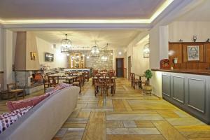 een restaurant met tafels en stoelen en een eetkamer bij Arion Hotel in Delfoi