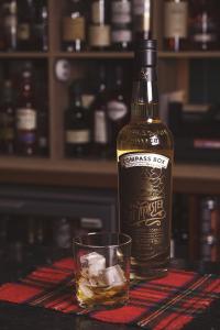 a bottle of whiskey and a glass on a table at Bannockburn Inn in Helmsdale