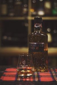 a bottle of whisky and a glass on a table at Bannockburn Inn in Helmsdale