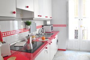 a kitchen with white cabinets and white appliances at Sevilla Central Suites Apartamentos Fabiola in Seville