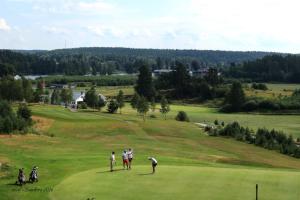 a group of people playing golf on a golf course at Residence Marmorvägen in Karlstad