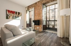 a living room with a white couch and a brick wall at Puerta Del Sol City Center II in Madrid