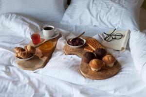 a breakfast tray with pastries and a book on a bed at Elaion Terra Boutique Guesthouse in Theológos