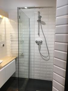 une douche dans une salle de bain avec du carrelage blanc dans l'établissement Siwa Skała, à Kościelisko 64 autres photos
