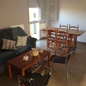 Los UrrutiasにあるApartamentoのリビングルーム(ソファ、テーブル、椅子付)