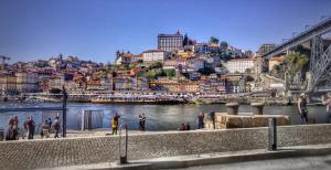 a group of people standing on a sidewalk next to a river at Portus Ribeira House in Vila Nova de Gaia