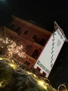 un panneau dans la neige devant un bâtiment dans l'établissement Albergo Al Castello, à Recoaro Terme