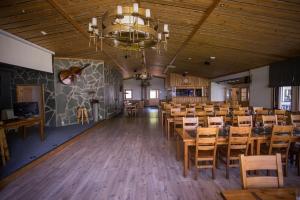 a dining room with tables and chairs and a chandelier at Kuus-Hukkala in Harkala