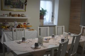 a dining room with a white table with white chairs at B&B La Colomba in Altamura +49 photos