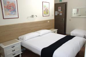 una camera d'albergo con due letti e un lavandino di In vacanza da Sara a Roma