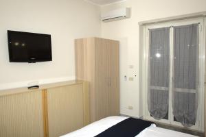 ローマにあるIn vacanza da Saraのベッドルーム1室(ベッド1台、壁掛けテレビ付)