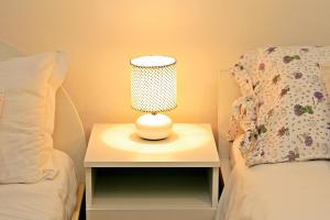 una lámpara en una mesita de noche junto a una cama en Supetar Apartment City Center, en Supetar