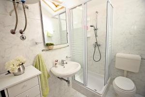 Un baño blanco con ducha y lavabo. en Supetar Apartment City Center, en Supetar 9 fotos más