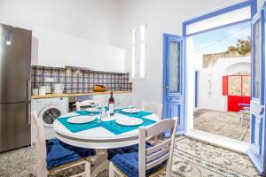 a dining room with a table and a kitchen at The red door in Koskinou in Koskinou +23 photos