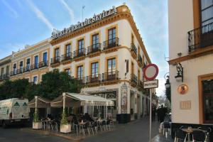 um edifício com mesas e cadeiras em frente em La Casa del Conde Ybarra em Sevilha