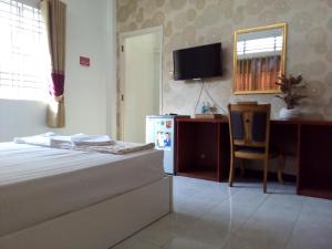 een slaapkamer met een bed, een bureau en een stoel bij Mekong Hotel & Restaurant in Ben Tre