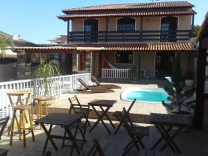 a patio with tables and chairs and a swimming pool at Casa com Piscina 6 Quartos in Araruama