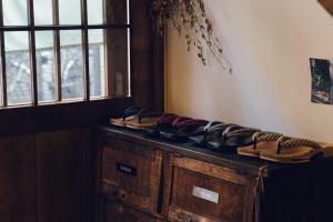 a pile of shoes sitting on top of a wooden cabinet at hanare in Tokyo