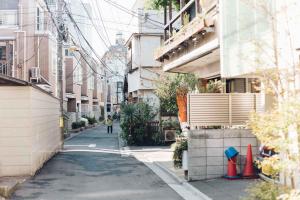a person walking down a street between buildings at hanare in Tokyo