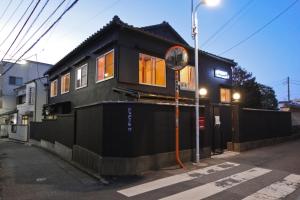 a black tiny house on the side of a street at hanare in Tokyo