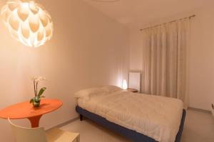 a bedroom with a bed and a table and a chandelier at Casa Laruccia B&B in Conversano