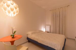 コンヴェルサーノにあるB&B Casa Larucciaのベッドルーム1室(ベッド1台、テーブル、シャンデリア付)
