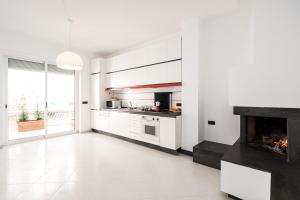 コンヴェルサーノにあるB&B Casa Larucciaの白いキャビネットと暖炉付きのキッチン